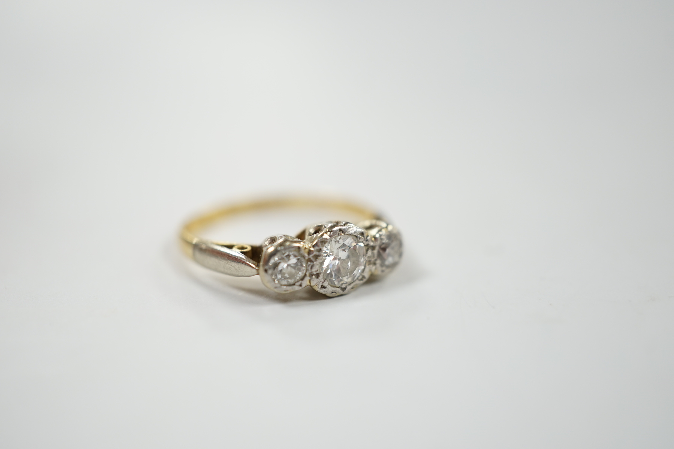 An 18ct, plat and illusion set three stone diamond ring, size J/K, gross weight 2.6 grams.